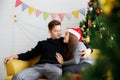 Young happy couple embracing and relaxing on comfortable couch. Lovely couple sitting on sofa and hugging Royalty Free Stock Photo