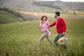 A young happy couple enjoying the nature and a large meadow while looking for a picnic spot. Love, relationship, together, nature Royalty Free Stock Photo