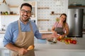 Young happy couple is enjoying and preparing healthy meal in their kitchen together Royalty Free Stock Photo