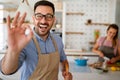 Young happy couple is enjoying and preparing healthy meal in their kitchen together Royalty Free Stock Photo