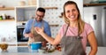 Young happy couple is enjoying and preparing healthy meal in their kitchen together Royalty Free Stock Photo