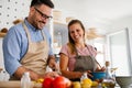 Young happy couple is enjoying and preparing healthy meal in their kitchen together Royalty Free Stock Photo