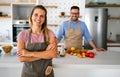 Young happy couple is enjoying and preparing healthy meal in their kitchen together Royalty Free Stock Photo