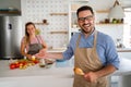 Young happy couple is enjoying and preparing healthy meal in their kitchen together Royalty Free Stock Photo