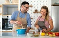 Young happy couple is enjoying and preparing healthy meal in their kitchen together Royalty Free Stock Photo