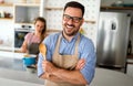 Young happy couple is enjoying and preparing healthy meal in their kitchen together Royalty Free Stock Photo