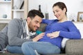 Young happy couple expecting baby on sofa Royalty Free Stock Photo