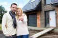 Young happy couple in front of their future house