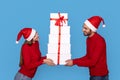 Young Happy Couple Handling Stack Of Gift Boxes With Red Ribbons