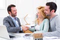 Young happy couple handshaking real estate agent after signing c Royalty Free Stock Photo