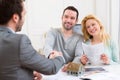 Young happy couple handshaking real estate agent after signing c Royalty Free Stock Photo