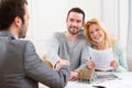 Young happy couple handshaking real estate agent after signing c Royalty Free Stock Photo