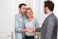 Young happy couple handshaking real estate agent after signing c Royalty Free Stock Photo