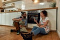 Young happy couple having glass of wine while cooking in the kitchen. Man and woman in apron waiting for pizza to be Royalty Free Stock Photo