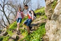 Young Happy Couple Hiking with Backpacks on the Beautiful Rocky Trail at Sunny Evening. Family Travel and Adventure. Royalty Free Stock Photo