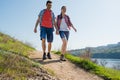 Young Happy Couple Hiking with Backpacks on the Beautiful Rocky Trail at Sunny Evening. Family Travel and Adventure. Royalty Free Stock Photo