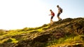 Young Happy Couple Hiking with Backpacks on the Beautiful Rocky Trail at Sunny Evening. Family Travel and Adventure.