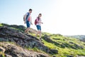 Young Happy Couple Hiking with Backpacks on the Beautiful Rocky Trail at Sunny Evening. Family Travel and Adventure. Royalty Free Stock Photo