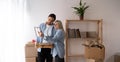 Young happy couple holding frame admires painting or photo at relocation day at new first home. Concept of remodeling Royalty Free Stock Photo