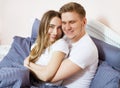 Young happy couple hugging in bed, family in bedroom after sleep, weekend