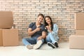 Young happy couple with key and moving boxes sitting on floor at new home Royalty Free Stock Photo