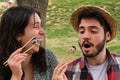 Young happy couple laughing and eating sushi in a park Royalty Free Stock Photo