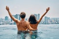 Young happy couple in love with arms up having fun in swimming pool Royalty Free Stock Photo