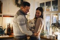 Young happy couple in love with cute little dog enjoying winter holiday season in cozy warm house Royalty Free Stock Photo