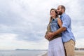 Young happy couple in love of a pregnant woman and her boyfriend hugging on the beach having fun on holidays. quality family time Royalty Free Stock Photo