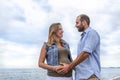 Young happy couple in love of a pregnant woman and her boyfriend hugging on the beach having fun on holidays. quality family time Royalty Free Stock Photo