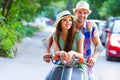 Young happy couple in love riding a retro scooter in the street Royalty Free Stock Photo