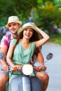 Young happy couple in love riding a retro scooter in the street Royalty Free Stock Photo