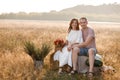 young happy couple in love sitting on straw stack in summertime in the park. Man and woman hugging, sunlight in summer Royalty Free Stock Photo