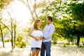 Young happy couple in love together on park landscape sunset with woman pregnant belly Royalty Free Stock Photo