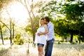 Young happy couple in love together on park landscape sunset with woman pregnant belly Royalty Free Stock Photo