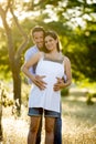 Young happy couple in love together on park landscape sunset with woman pregnant belly Royalty Free Stock Photo