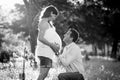 Young happy couple in love together on park landscape sunset with woman pregnant belly Royalty Free Stock Photo