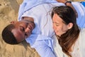 Young happy couple lying on the sand, top view Royalty Free Stock Photo