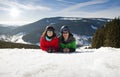 Young happy couple lying in snowy mountains. Winter sport vacation Royalty Free Stock Photo