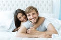 Young happy couple lying together in bed. Royalty Free Stock Photo