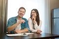 Young happy couple man and woman sitting in their new cosy apartment after successful lease sign both smiling Royalty Free Stock Photo