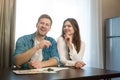 Young happy couple man and woman sitting in their new cosy appartments after successful lease sign both smiling Royalty Free Stock Photo