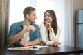 Young happy couple man and woman sitting in their new cosy appartments after successful real estate deal both smiling Royalty Free Stock Photo