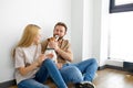 young happy couple is moving into new house, sitting down on floor with little puppy Royalty Free Stock Photo