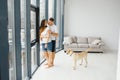 The young happy couple is moving into a new house. They are sitting down on the floor with their little puppy after they brought Royalty Free Stock Photo