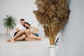 The young happy couple is moving into a new house. They are sitting down on the floor with their little puppy after they brought Royalty Free Stock Photo