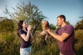 Young happy couple on nature,the boy gives girl a dog - yorkshire terrier as gift