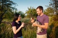 Young happy couple on nature,the boy gives girl a dog - yorkshire terrier as gift