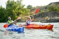 Young Happy Couple Paddling Kayaks on Beautiful River or Lake