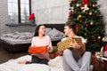 Young happy couple in pajamas laughing and rejoice at their pres Royalty Free Stock Photo